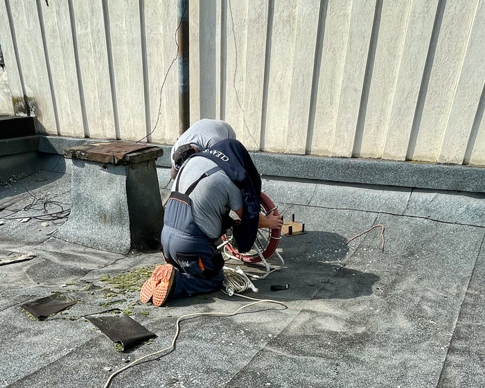 Plumbers at work on top of a ten storey building