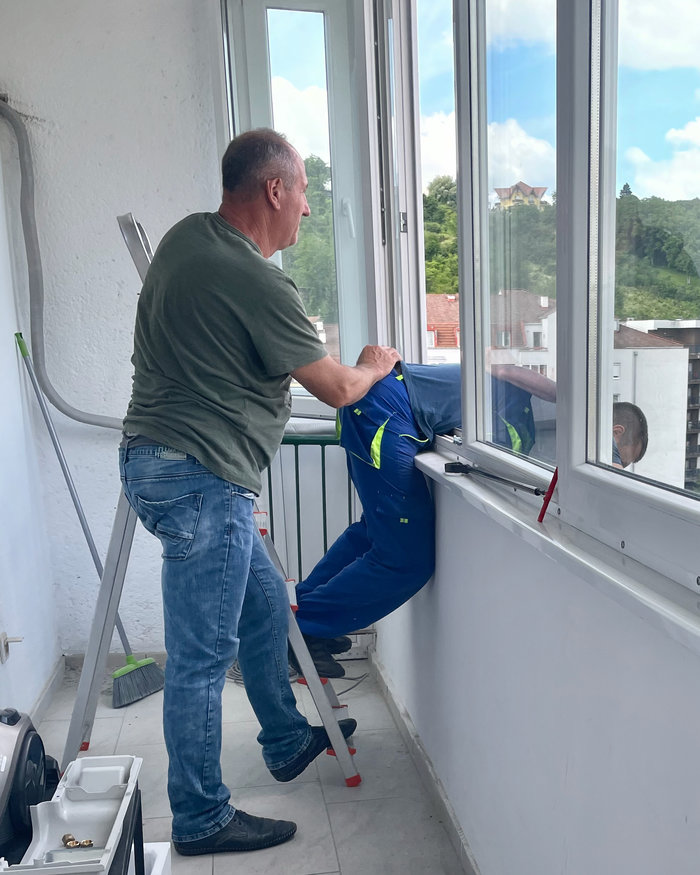 Repairmen fixing an A/C at a high-storey building